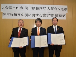 写真：3市長が協定書を提示