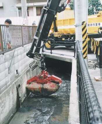 写真：クラムシェル付クレーン車による水路清掃