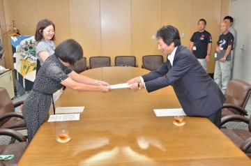 写真:福岡会長より答申を受け取る田中市長
