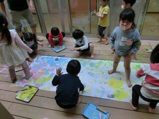 写真:手足を使って絵の具遊びをする子ども達