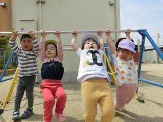 写真:鉄棒にぶら下がる幼児達