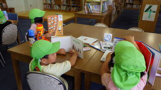 写真：机で本を読む子ども達