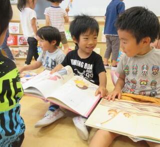 写真:絵本を見る子ども達