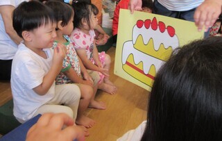 写真:大きなケーキの絵を見る子ども達