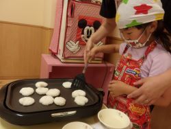 焼いているおやきをひっくり返す子ども