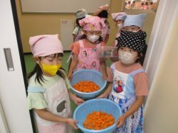 型抜きしたにんじんを調理室へ運ぶ様子