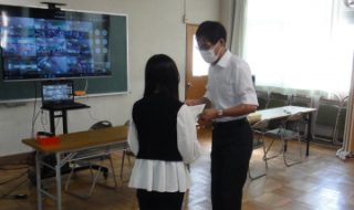 写真:会議室で賞状を手渡している様子