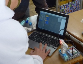 写真：考えた信号機のプログラムを実物を使って動作確認している様子