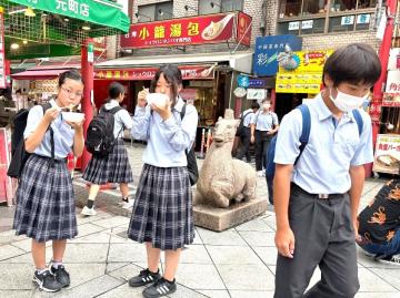 写真：南京町で食べ歩きをする生徒ら
