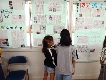 写真：壁新聞とそれを見る児童ら