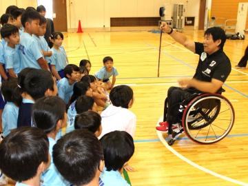 写真：永尾さんの銅メダルを見る児童ら