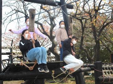 写真：ターザンロープで遊ぶ児童ら