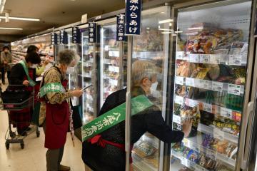 写真：冷凍ショーケースをチェックする女性