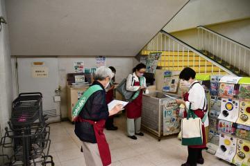 写真：リサイクルボックスをチェックする女性