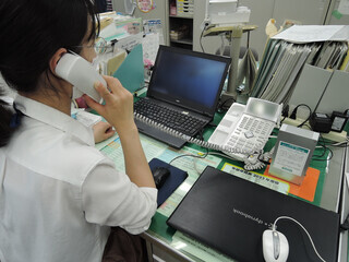 写真:電話音声明瞭器を使用する女性
