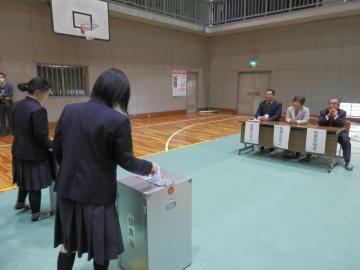 写真：投票箱に投票用紙を入れる生徒の様子