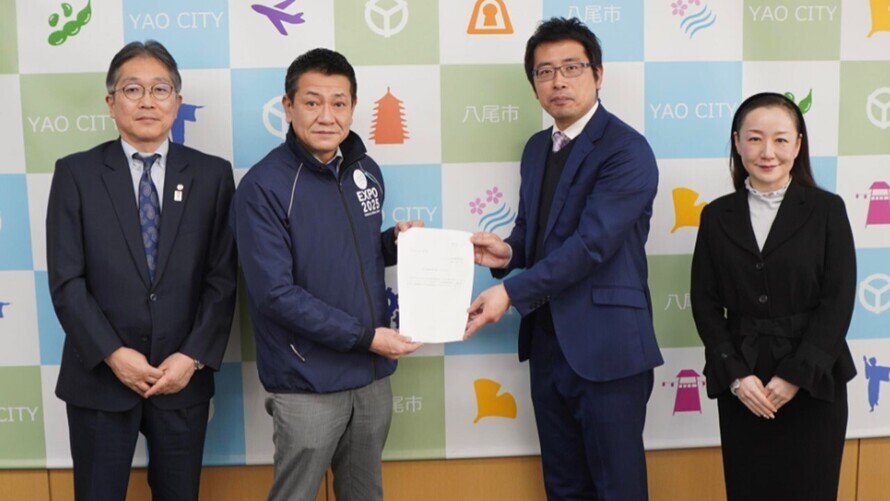 写真：座長より市長へ提言書を提出する様子