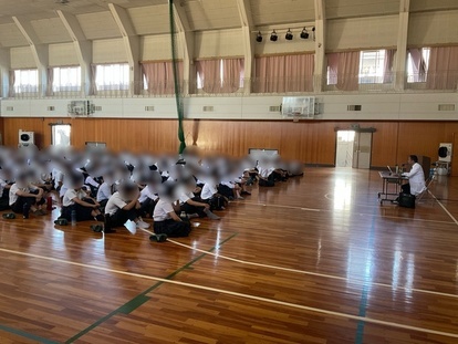 お医者さんの話を聞く生徒の写真