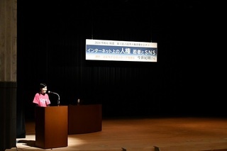 写真：ピンクシャツを着た司会者