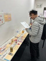 写真：糖質のモデル展示を見る男性