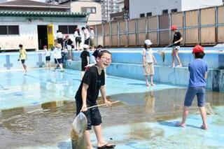 写真：汚れをすくいとり笑顔の児童