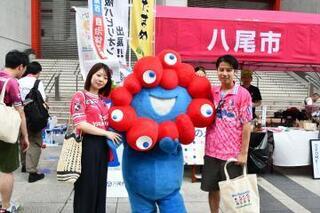 写真：ミャクミャクと記念撮影する男女