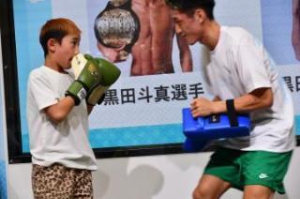 写真：ステージでミット打ちをする男の子