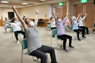 写真：座りながら大きく両手を広げる運動
