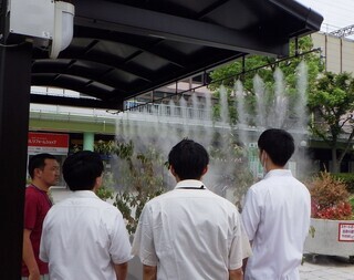 写真:ミスト装置を確認する大学生ら