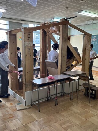 写真:木製のブランコが人を乗せて動いている様子