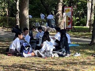 写真：公園内の屋外で昼食をとる学生ら1