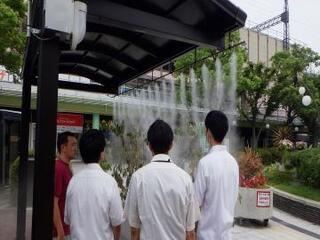 写真：ミスト装置を確認する大学生ら