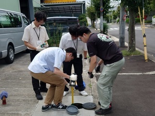 写真：下水道管を点検する大学生ら