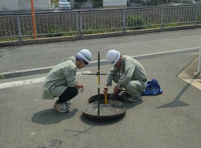 写真：下水道管を点検する大学生ら