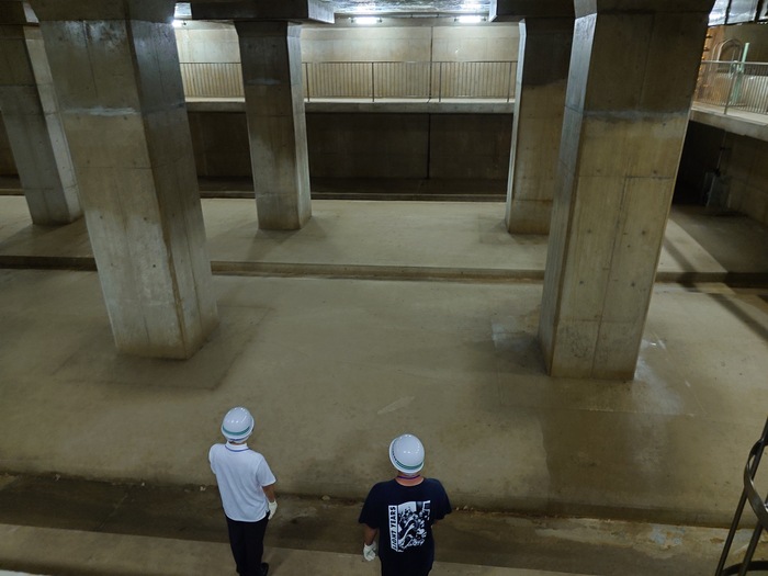 写真：雨水貯留施設を点検する大学生ら