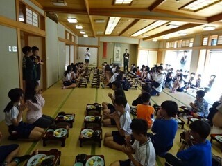 写真:大広間で一人一膳の朝ご飯を食べる児童ら