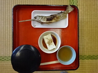 写真:イワナの塩焼きと冷ややっこなどが載った膳