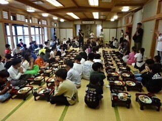 写真:大広間で一人一膳の夕食を食べる児童ら1