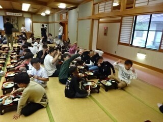 写真:大広間で一人一膳の夕食を食べる児童ら2