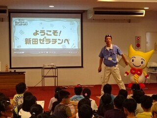 写真:児童らを出迎える新田ゼラチンの担当者とゼラちゃん