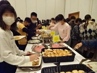 写真：バイキング会場で朝食を取り分ける児童ら