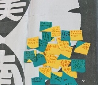 写真：子どもたちが夢や大切にしていることなどを書いた緑や黄色、また両方が混じった約5cm四方の紙