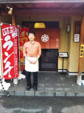 写真:店の入り口に立つ店主
