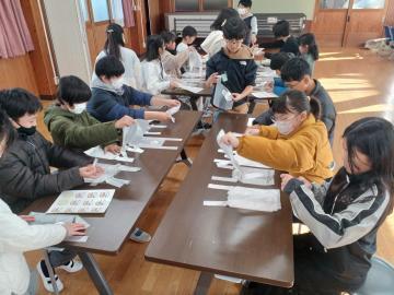 写真：ハボタン苗を入れるレジ袋へのラベル貼り