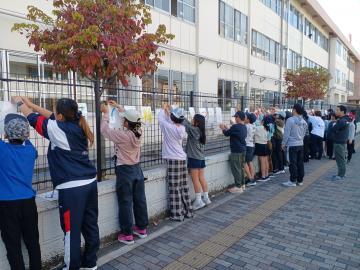 写真：学校フェンスに配布告知看板取り付け3