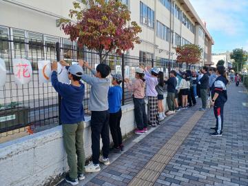 写真：学校フェンスに配布告知看板取り付け1