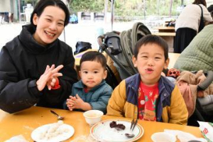 写真：笑顔でお餅を食べる親子