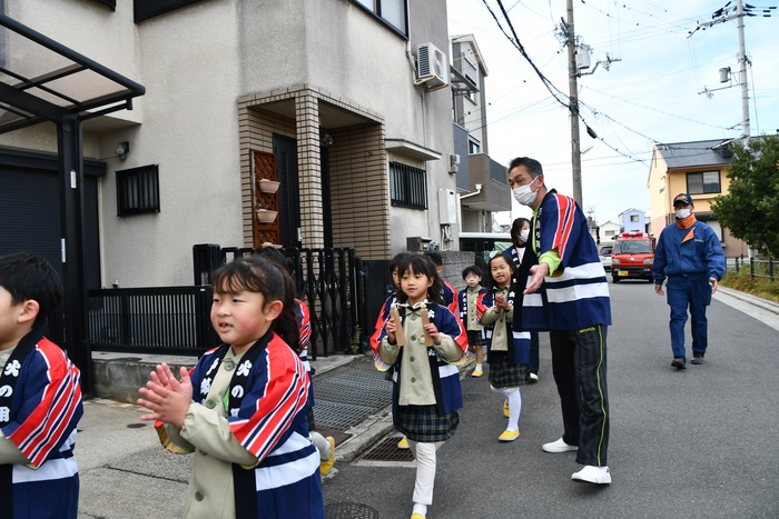 手をたたき呼びかける児童