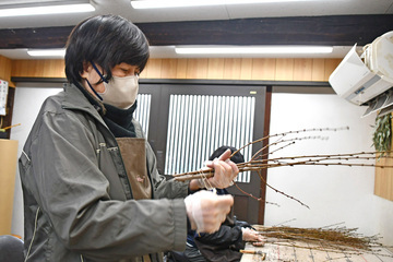 写真：ひもで束ねる女性