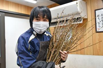 写真：ハナモモの束を抱える女性